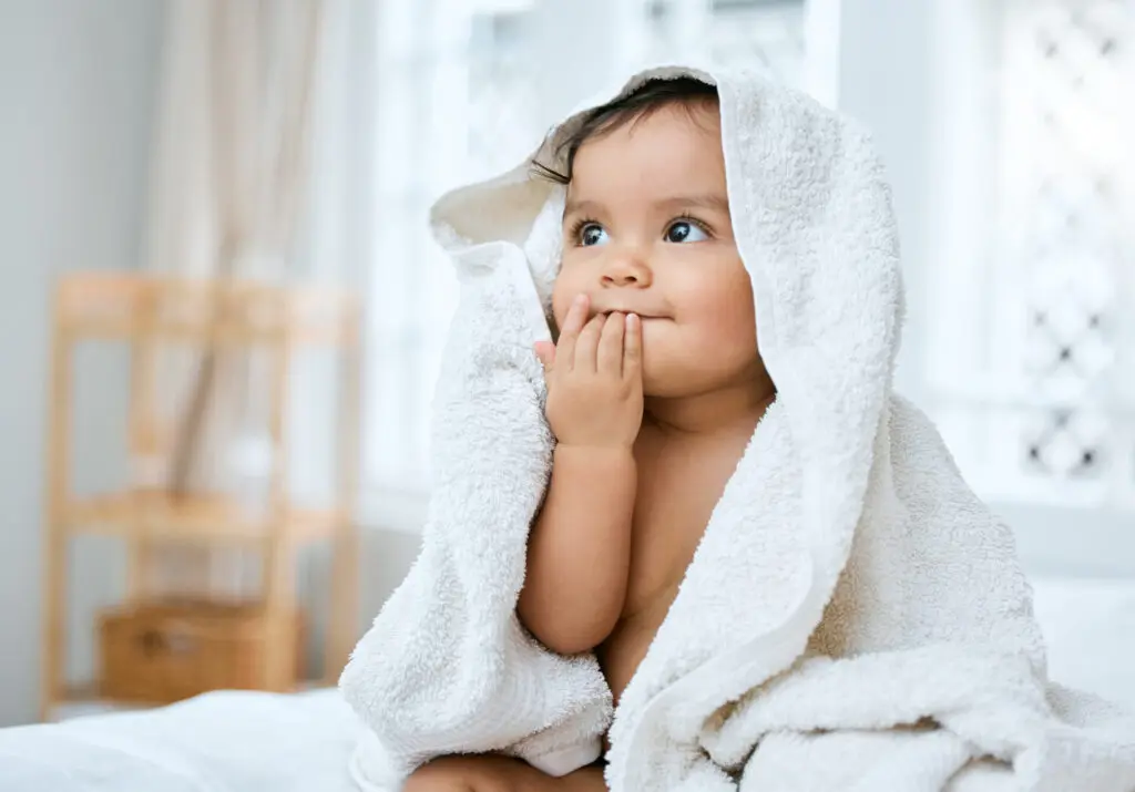 a baby wrapped in a white towel thinking of maternity photoshoot ideas