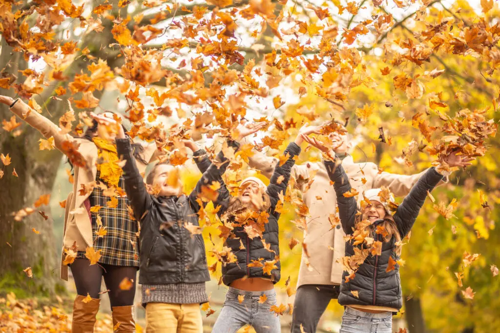 a group of people throwing leaves up in the air