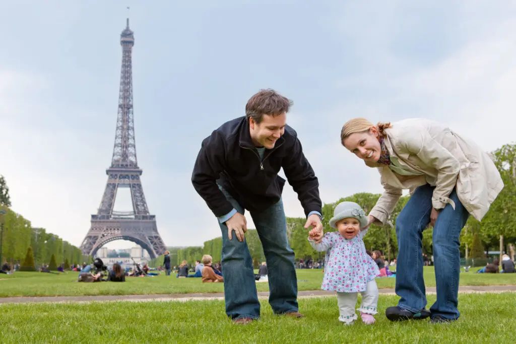a man and woman with a baby in front of a tower