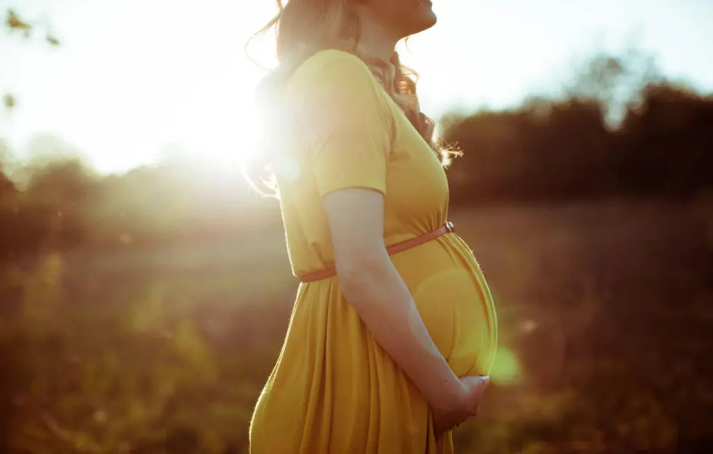 a pregnant woman in a yellow dress