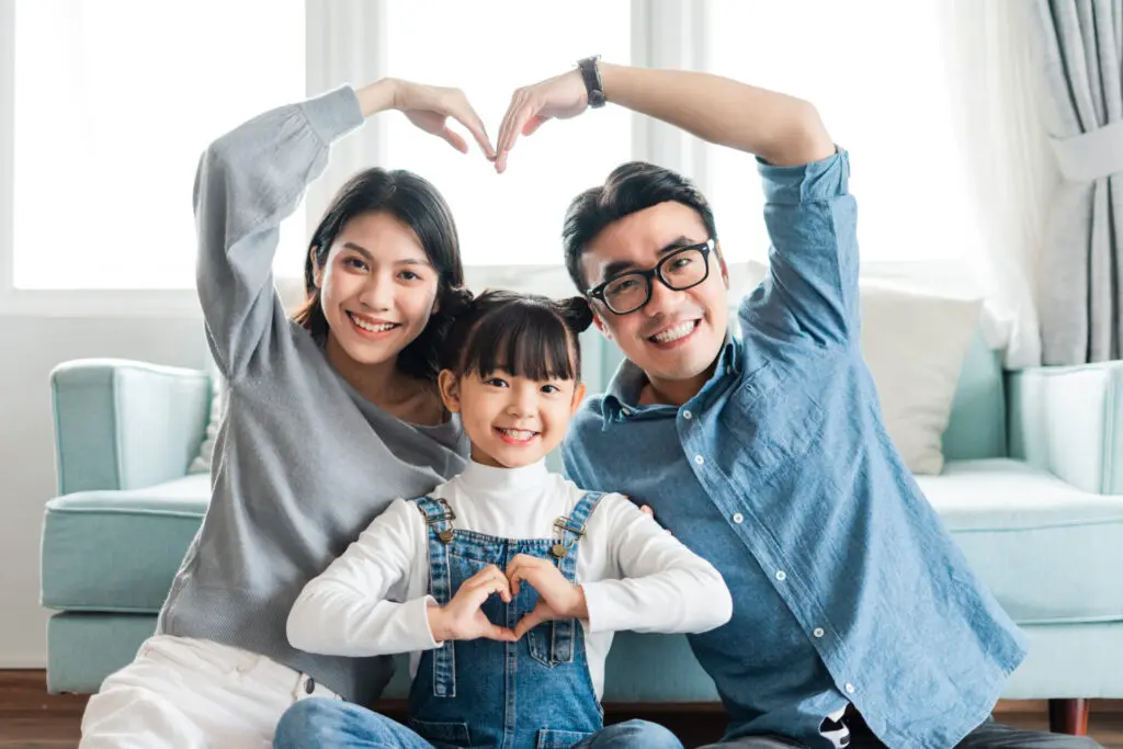a man woman and child making a heart with their hands